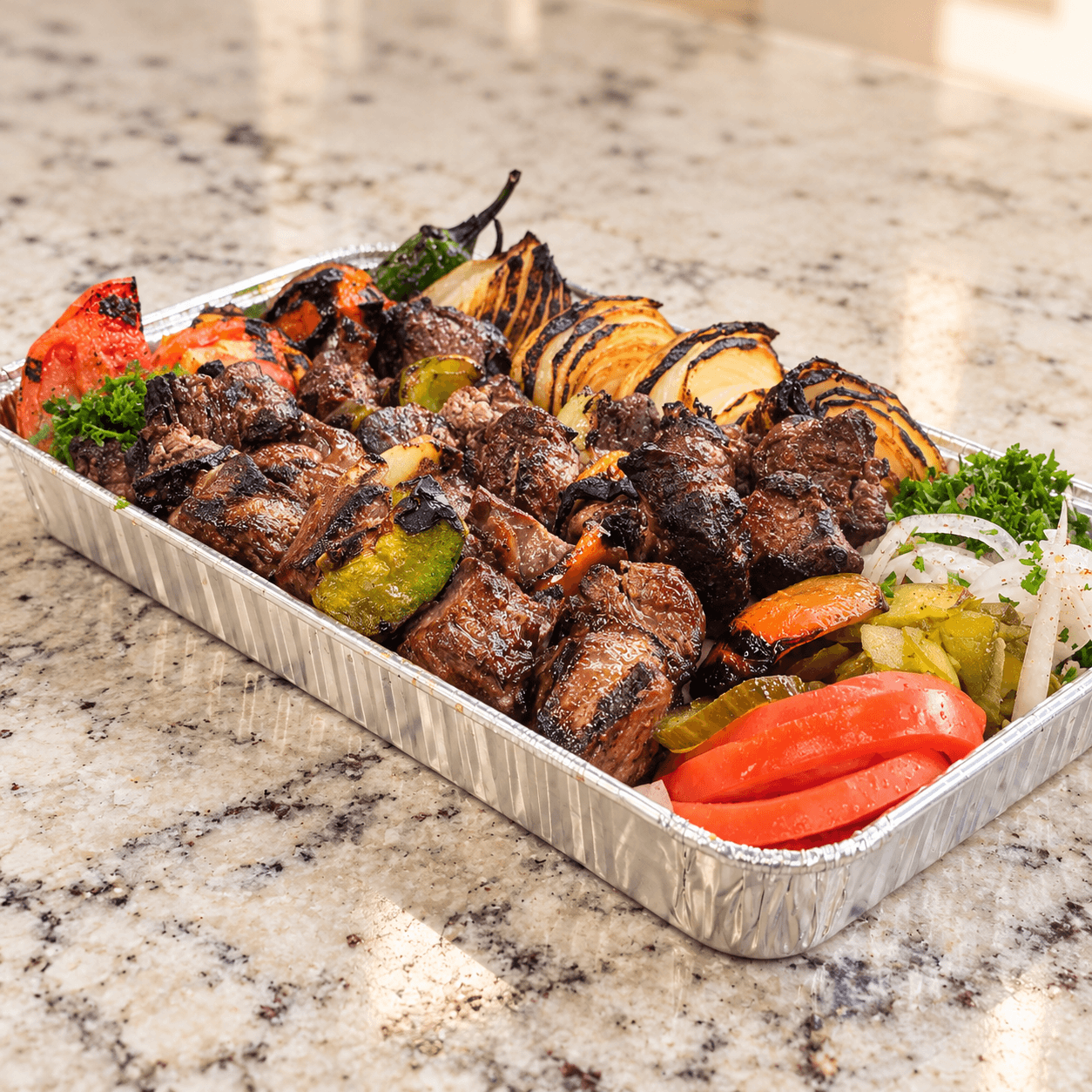 Charcoal-grilled shish kabob with grilled onions, peppers and tomatoes