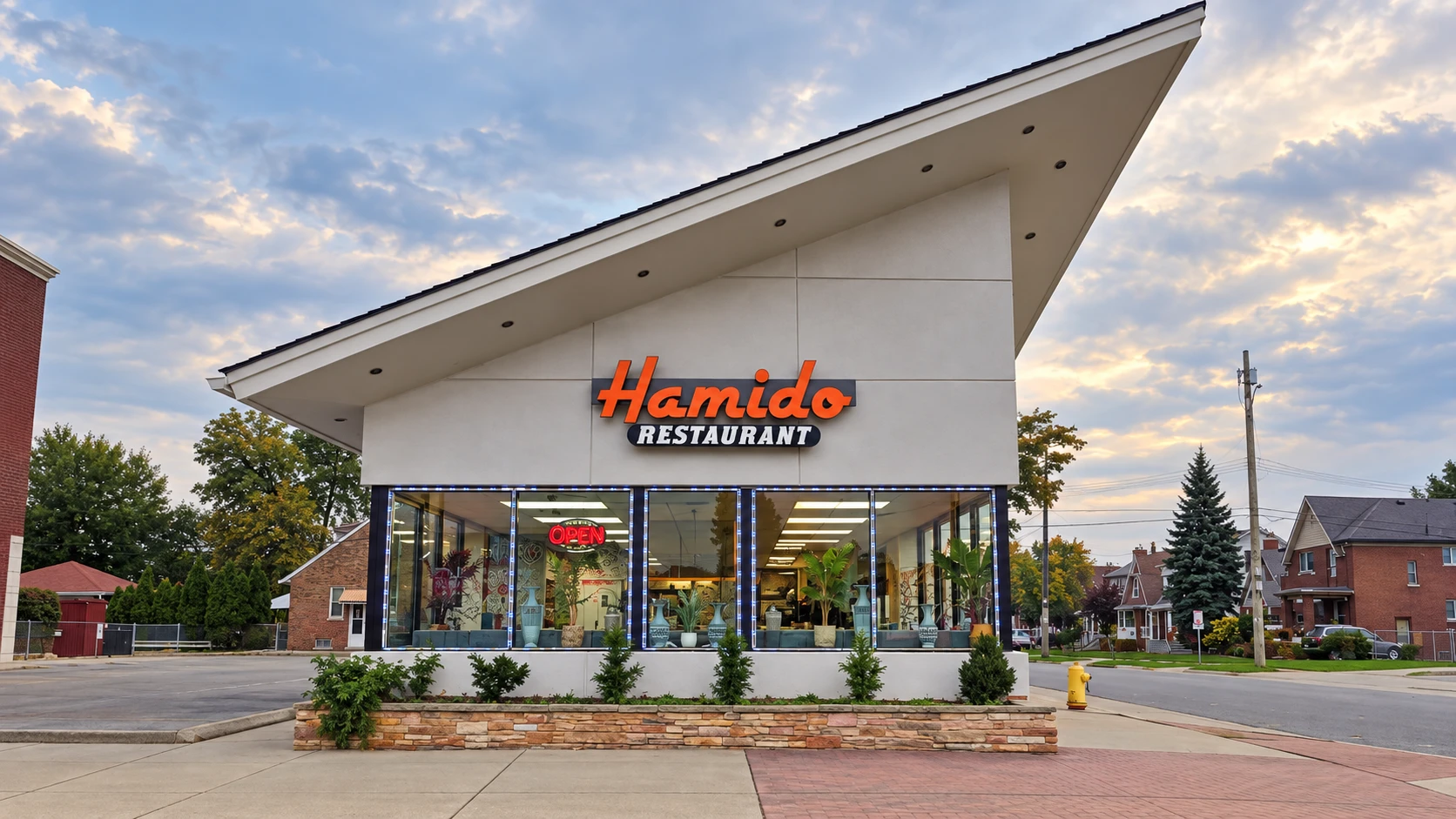 Hamido Restaurant in Dearborn: the white building with the sloped roof and orange Hamido sign on W Warren Ave at dusk